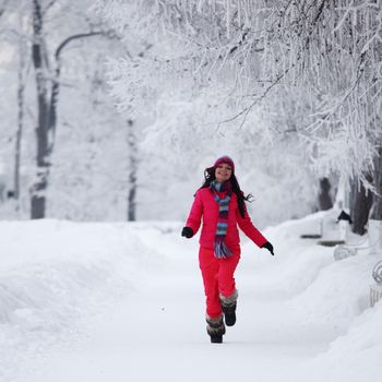 woman run in winter park very happy