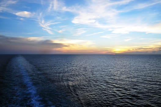 Sunset approaches as a cruise ship sails the Caribbean.