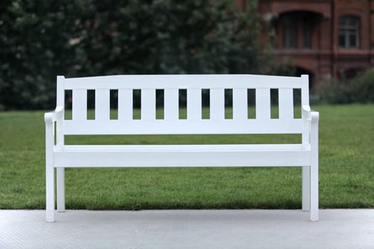 White wooden bench on green grass
