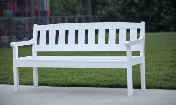 White wooden bench on green grass