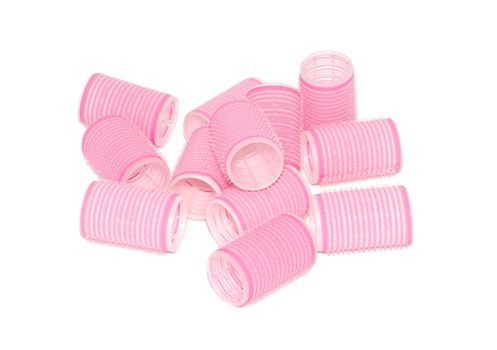 Twelve pink velcro rollers in a jumbled pile, isolated on a white background