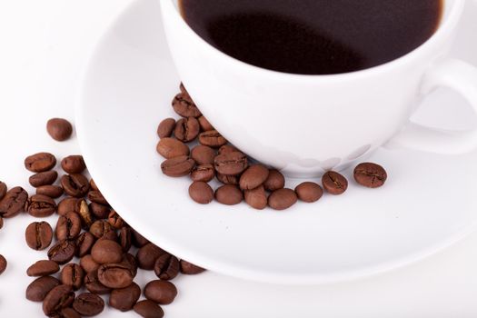 Cup of coffee on a plate with coffee beans