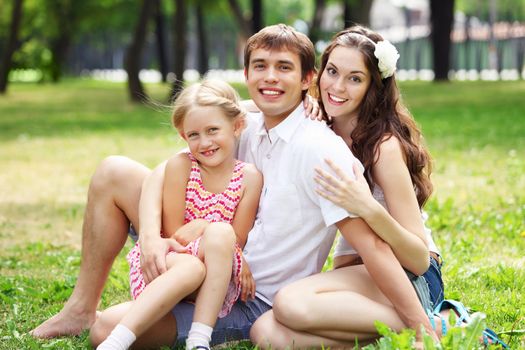 Young Family Outdoors on the grass in Park in summer