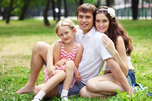 Young Family Outdoors on the grass in Park in summer