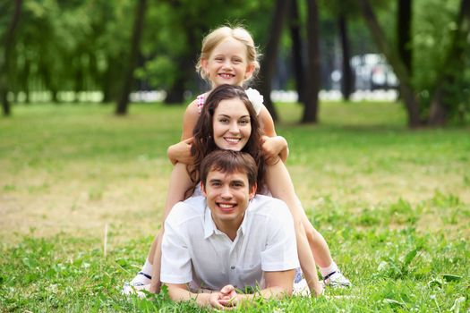 Young Family Outdoors on the grass in Park in summer