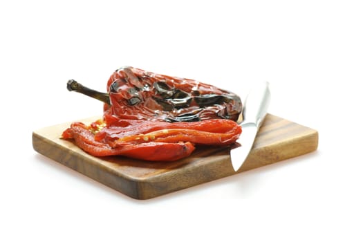 Fire roasted sweet red pepper photographed on a white background.