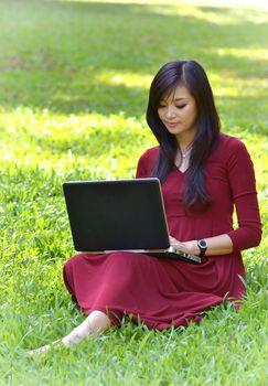 pretty  woman with laptop on green grass at the garden 