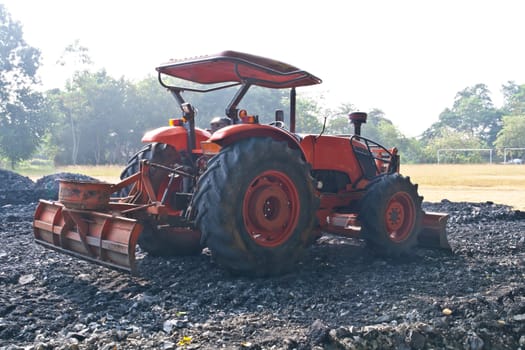 The tractor gravel Rouge in Football field.