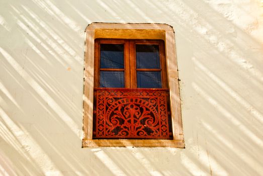 Sunlight streaks walls and decorative window  of Colonial Mexico