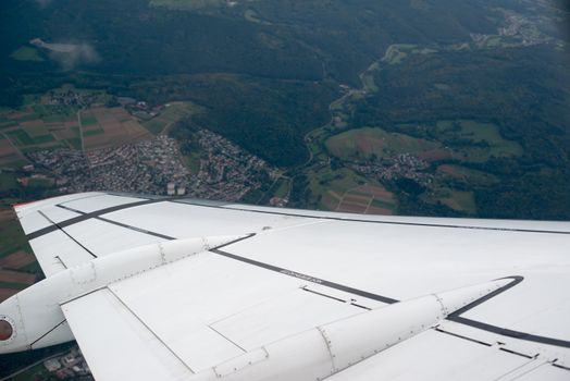 airplane wing and landscape as seen through the cabin window