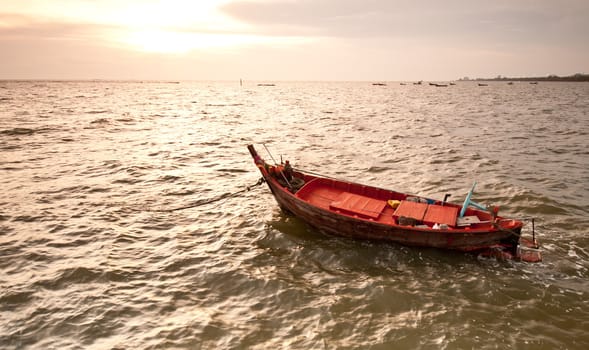 A small wooden fishing boat  floating in the sea