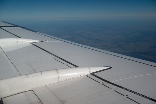 airplane wing, sky and clouds as seen through the cabin window
