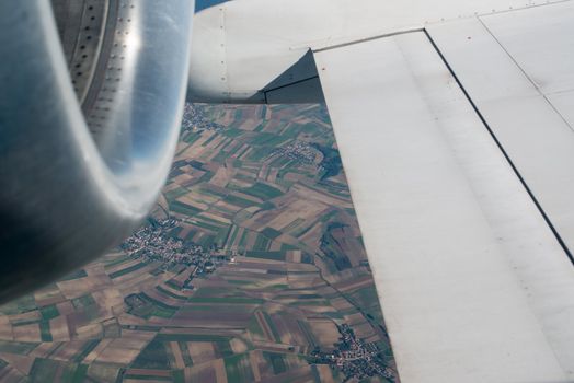 airplane wing, turbine, landscape as seen through the cabin window
