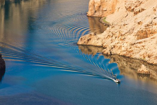 Boat leaving waves in Zrmanja river canyon, Dalmatia, Croatia