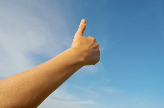 Woman's hand on blue sky 