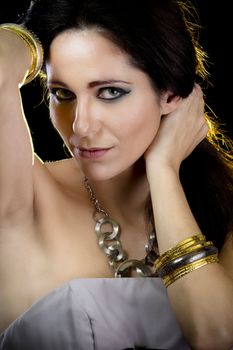 Elegant woman with golden light, gold and silver jewelry