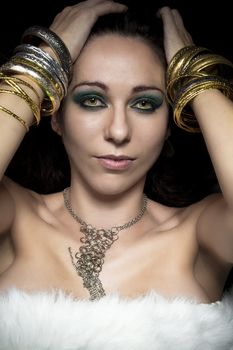 Elegant and sensual woman with golden light, gold and silver jewelry