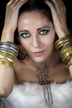 Woman lying and sensual with bracelets of gold and silver, looking