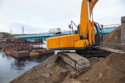 Excavator builds a bridge. Russia. North. Taiga.