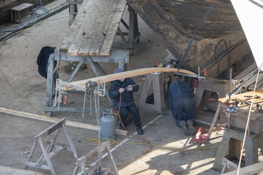 HELLEVOETSLUIS,HOLLAND-AUGUST 31:Unidentified people bending wood in the dry dock for renovation of russian frigat,on August 31,2012 in Hellevoetsluis,Holland.This renovation is only once in 13 years.