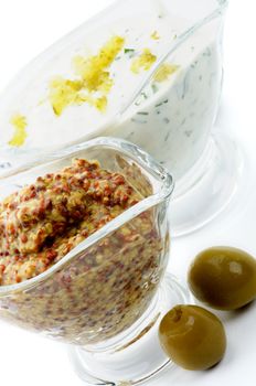 Whole Grain Mustard and Tartar Sause with two Olives in Glass Gravy Boat isolated on white background