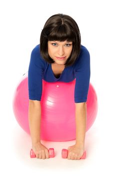 Instructor taking exercise class using ball and dumbbells at gym