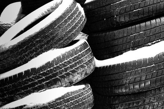 Stacks of Worn Tires in the Snow.