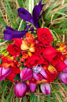 Wedding rings sit on a bride's bouquet during a wedding day ceremony.