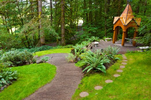 A beautiful path leads to a wooden gazebo in a perfectly manicured green natural garden at an Oregon wedding venue.