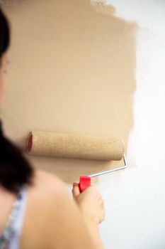 Woman is painting a wall