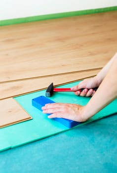 Repair of a floor covering. Man laying the floor panels