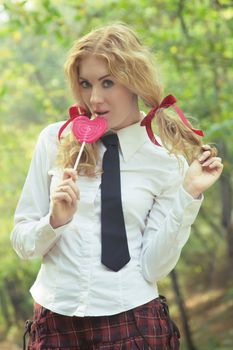 Attractive schoolgirl in tie with lollipop
