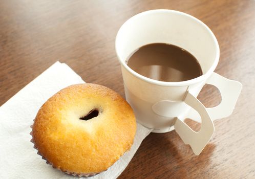 A paper cup of coffee and bakery serve on break