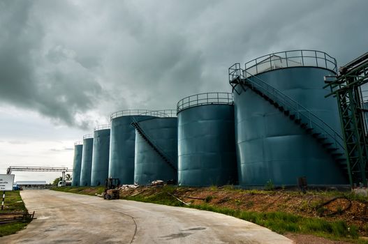  Vertical picture of  storage tanks and ladder on cloudy background
