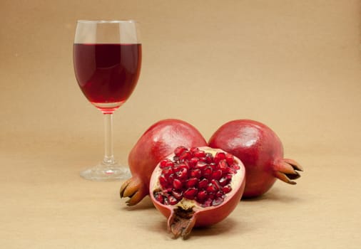 Pomegranate juice in a wine glass and ripe pomegranate