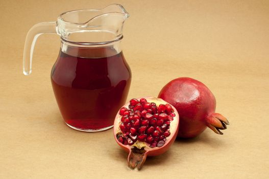 Pomegranate juice in a jug and ripe pomegranate