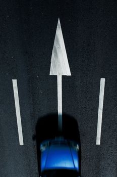 road marking: white arrows  on the dark asphalt road. with  car movement