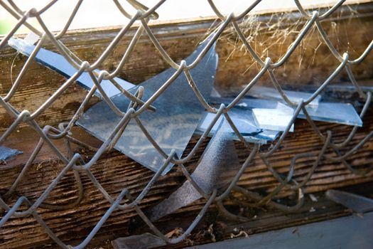 Broken glass in a chain link fence in an urban setting.







Broken glass in a chain l