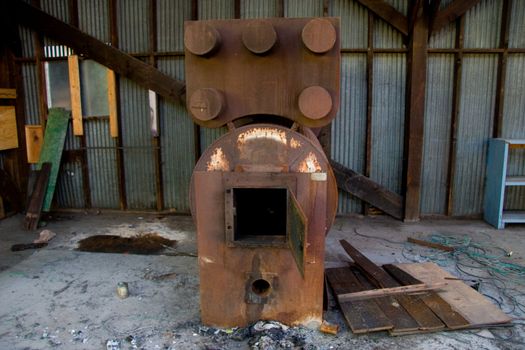 An old instrument at a warehouse stands rusted and unused.