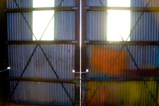 Light comes through the windows of two doors at a warehouse building.