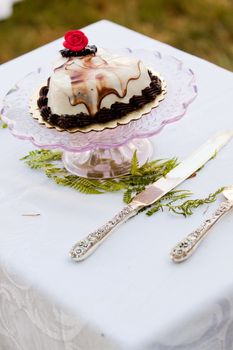 A wedding cake on a cake serving platter at a ceremony.