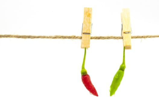 Red and green chilli hanging on clothespin