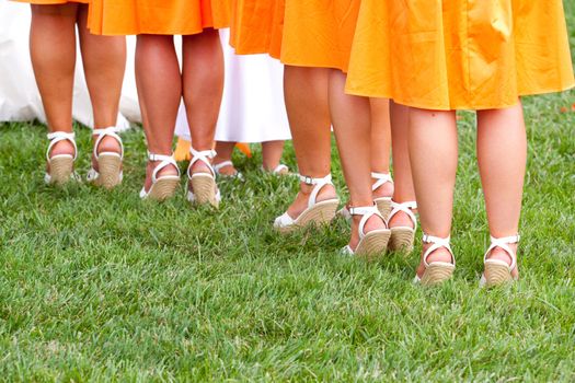 A photo of the feet and legs of bridesmaids during a wedding ceremony.