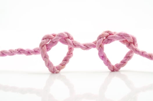 pink rope heart shaped symbol, isolated on a white background