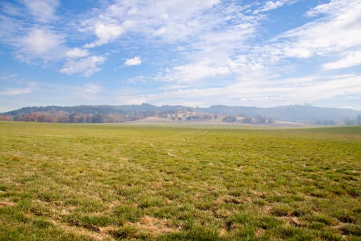 Grass and sky come together along the horizon in this landscape shot of a very large field.