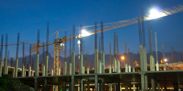 Industrial construction cranes and building at night