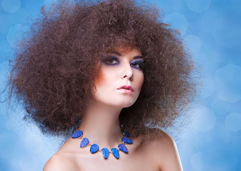 woman with curly hair with blue make-up