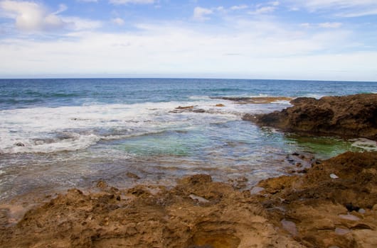 A beautiful beach with nobody in the scene as well as a dynamic sky and nice turquoise and blue tones throughout in color.