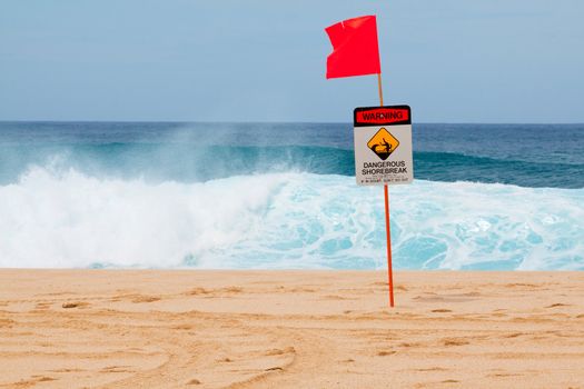 Warning signs mark where there is a very dangerous shore break and rip current along the north shore of Oahu Hawaii.