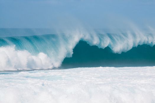 Large waves break off the north shore of oahu hawaii during a great time for surfers surfing.